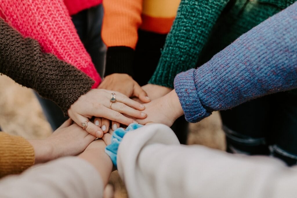 Gruppo di persone unisce le mani, simbolo di collaborazione